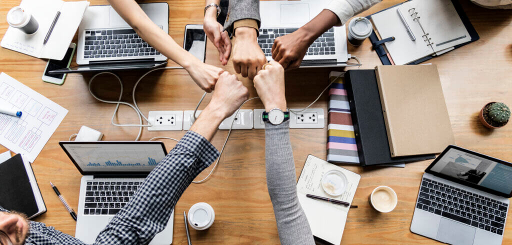 Equipo uniendo las manos como símbolo de colaboración